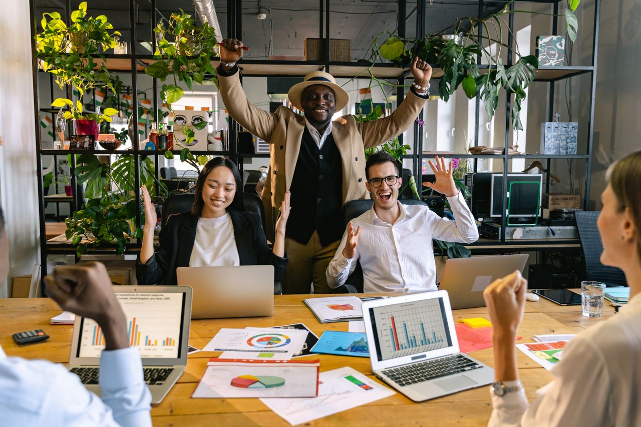 Colleagues celebrate a successful meeting in a vibrant office environment.
